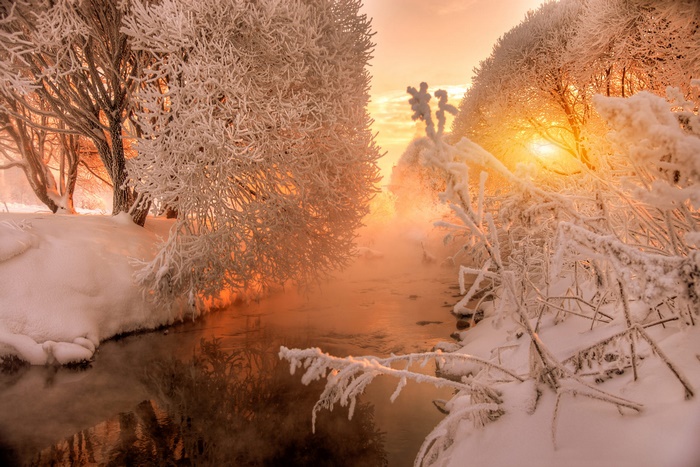 Winter river at sunset with snow-covered trees