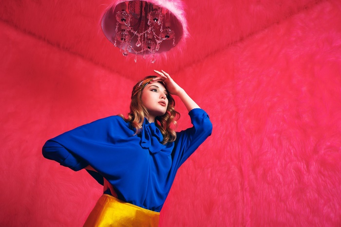 Woman in blue blouse and yellow skirt with pink fur room