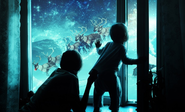 Children watching Santa's sleigh with reindeer in the night sky