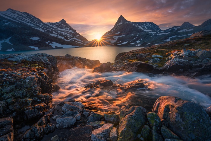 Sunset over a mountain lake with a stream in Norway