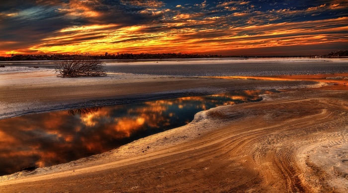 Sunset over a body of water with reflections