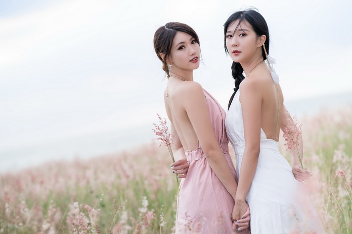 Two Asian Women in Pastel Dresses in Field 4K