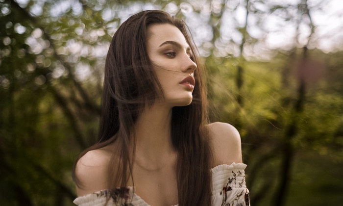 Woman with long brown hair in a white dress