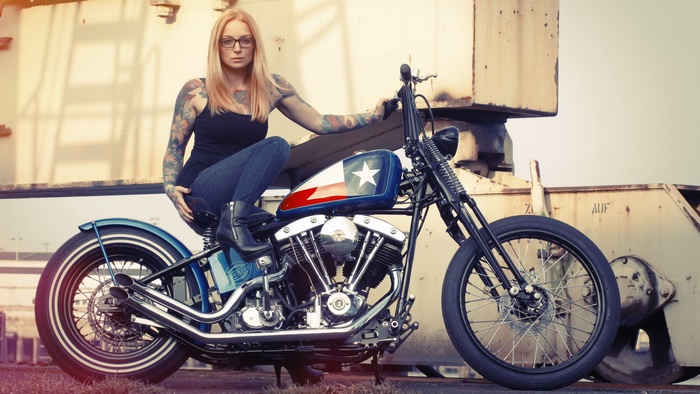 Blonde tattooed woman on a custom motorcycle