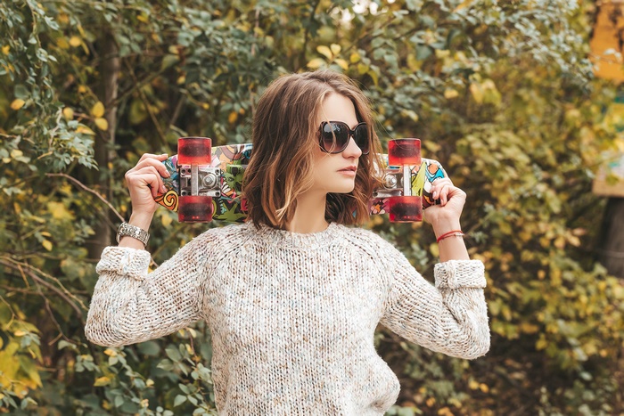 Woman with skateboard and sunglasses
