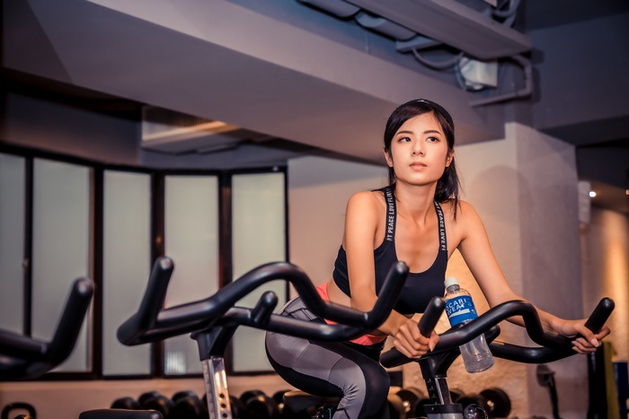 Asian woman exercising on a stationary bike