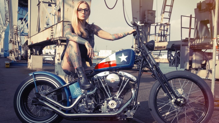 Blonde woman with tattoos on a motorcycle
