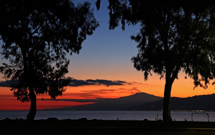 Sunset over the sea with Mount Etna volcano in Sicily, Italy
