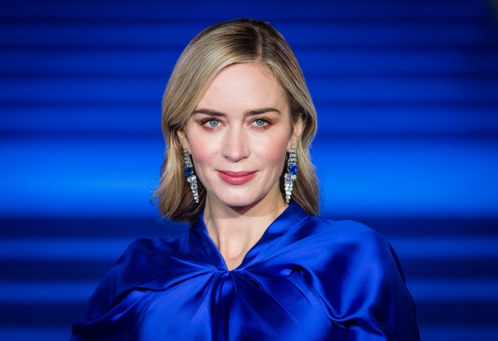 Emily Blunt wearing a blue dress and earrings