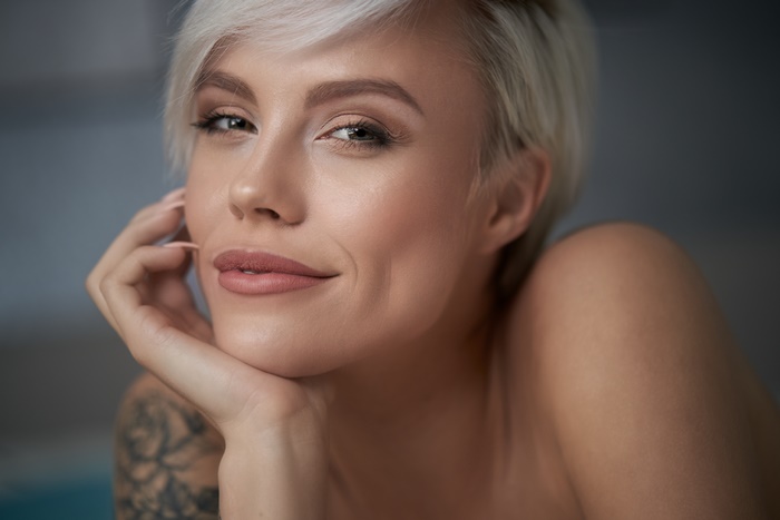 Blonde woman with tattoo smiling