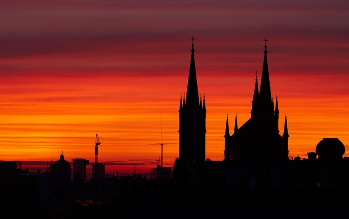 Church silhouette against a vibrant sunset in Vienna, Austria
