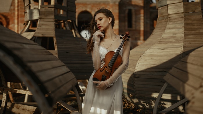 Woman in white dress holding a violin
