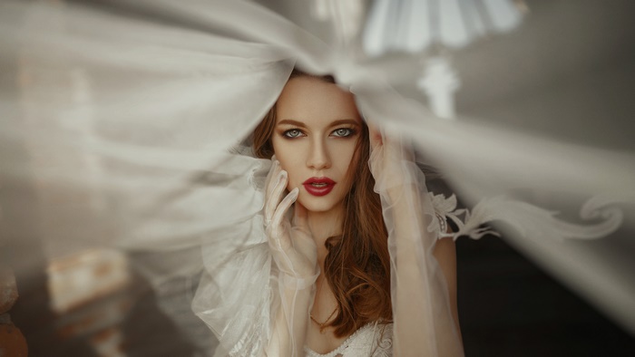 Woman with red hair and blue eyes under a veil