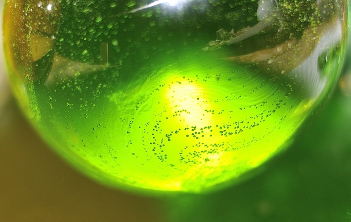 Abstract green liquid with bubbles and light reflections