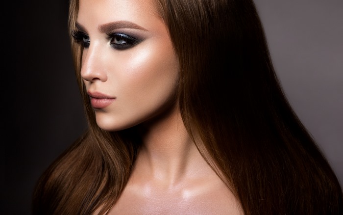 Woman with dramatic eye makeup and long brown hair