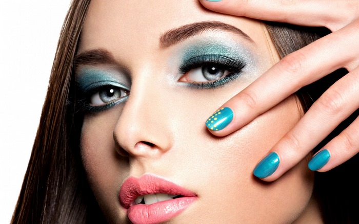 Woman with blue eye makeup and pink lips