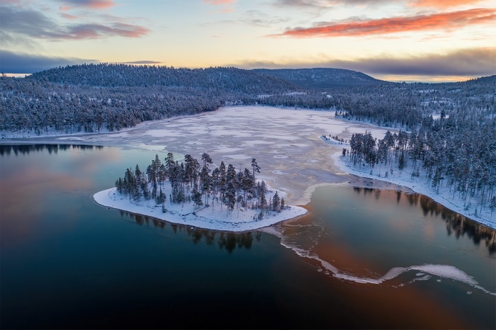 Winter island landscape with frozen lake and forest in Finland