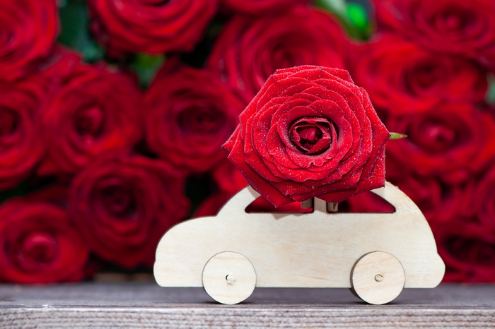 Red rose in a wooden car with a bouquet of roses