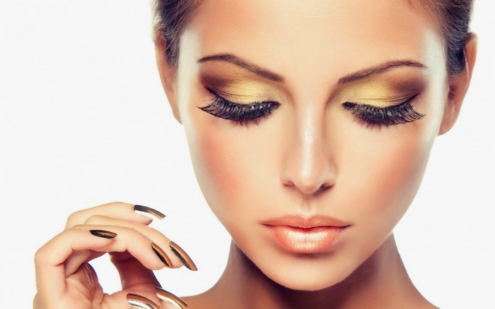 Woman with golden makeup and long nails
