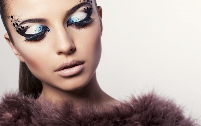 Woman with dramatic makeup and feather boa