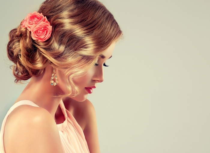 Woman with elegant updo and rose hair accessory