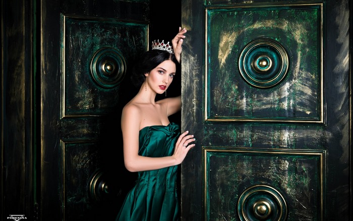 Model in a green dress wearing a crown