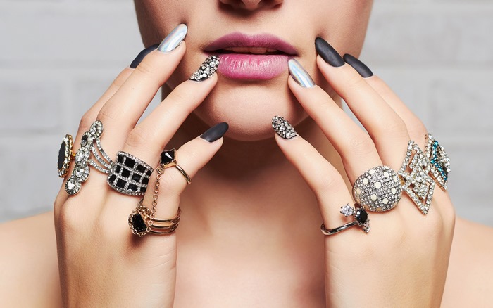 Woman with multiple rings and decorated nails