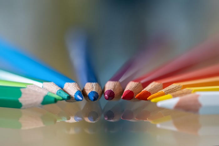 Colored pencils arranged in a semi-circle with reflections