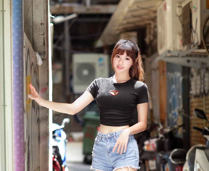 Woman in black crop top and denim shorts