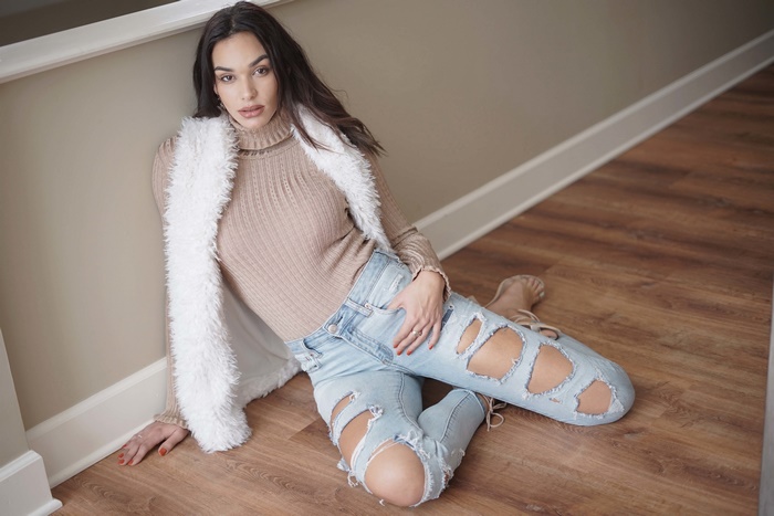 Woman in ripped jeans and fur vest