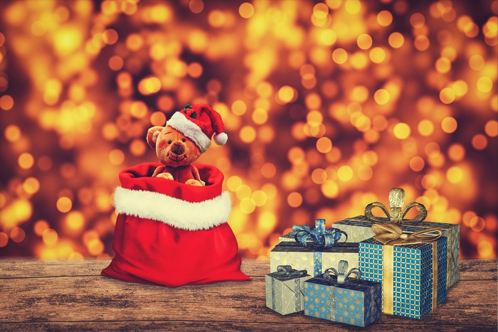 Christmas Teddy Bear in Santa Bag with Gifts and Bokeh