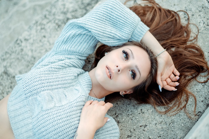 Woman lying down wearing a sweater