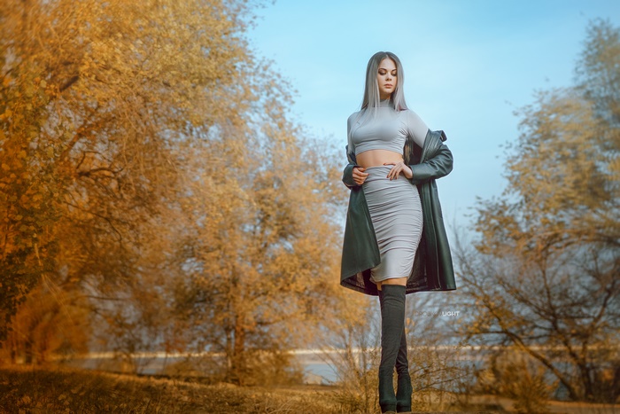 Woman in grey outfit and boots in autumn park
