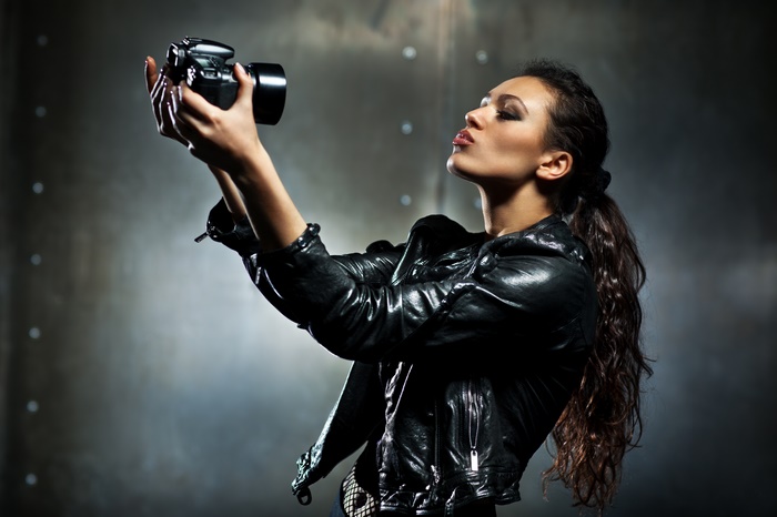 Woman with Long Hair in Leather Jacket Taking Photo
