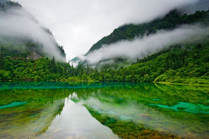 Misty Mountains Overlooking a Green Lake