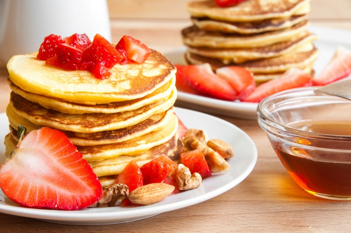 Pancakes with strawberries, nuts, and honey