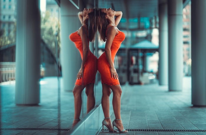 Woman in red dress reflected in glass