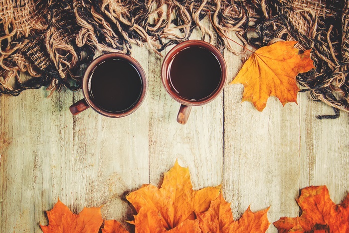 Two cups of coffee with autumn leaves