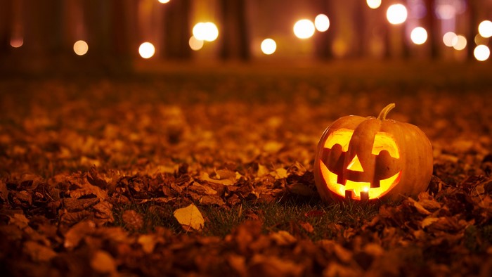 Jack-o'-lantern on fallen leaves at night