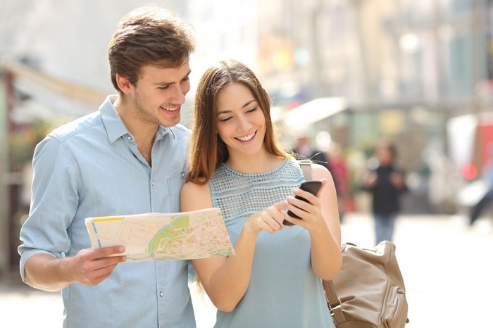 Couple looking at map and phone on street