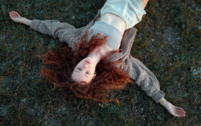 Redhead woman lying on grass