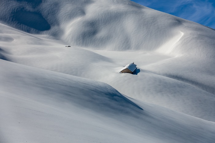 Snowbound house on a snowy mountain hill in winter