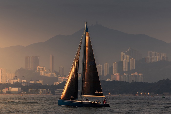 Sailboat on the water with Hong Kong skyline and mountains