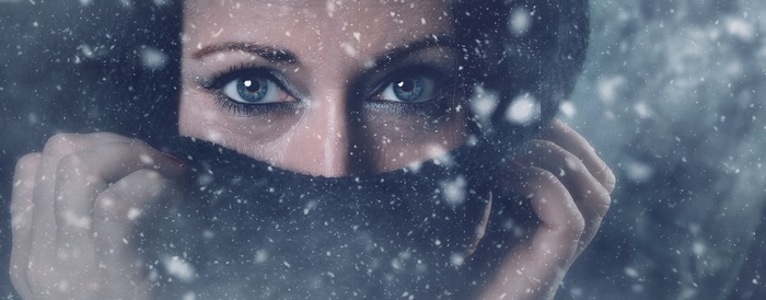 Woman's eyes peeking through scarf in snow
