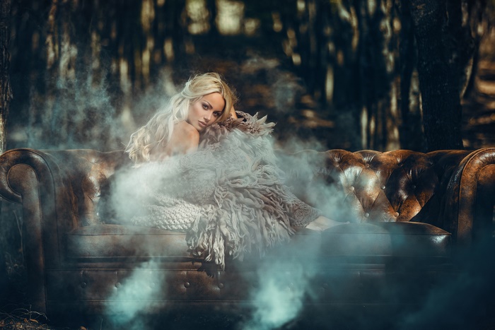 Blonde model on a sofa in a forest
