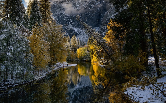 River reflecting autumn trees and snowy mountains