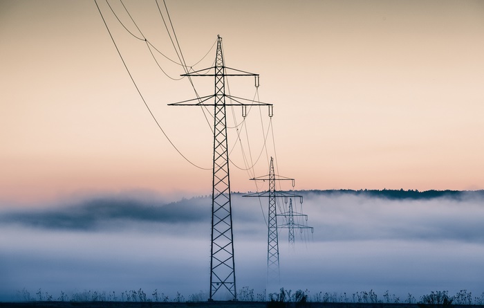 Power lines in fog at sunrise