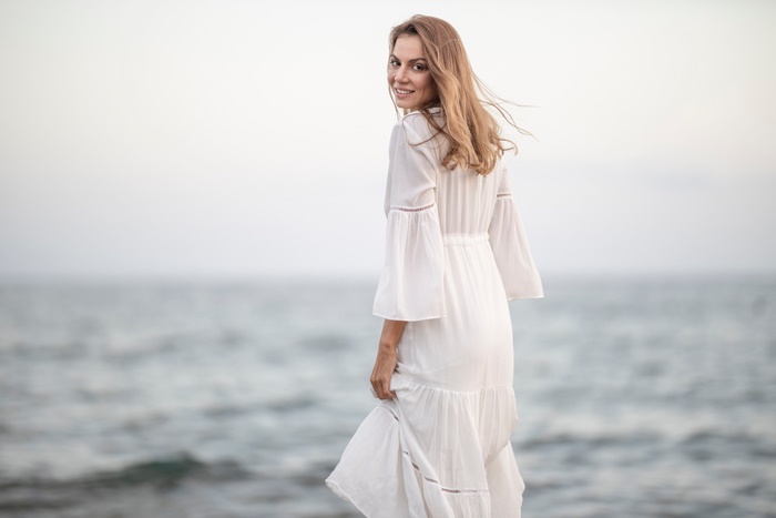 Woman in white dress by the sea