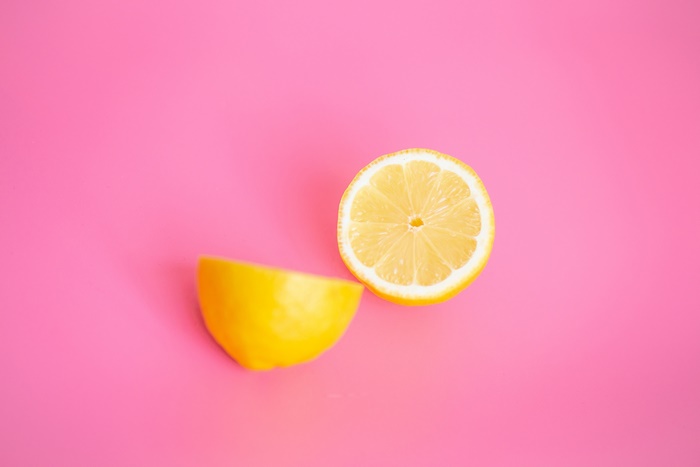 Two halves of a lemon on a pink background