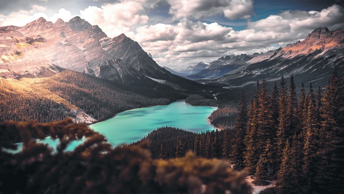 Turquoise lake surrounded by pine forest and mountains